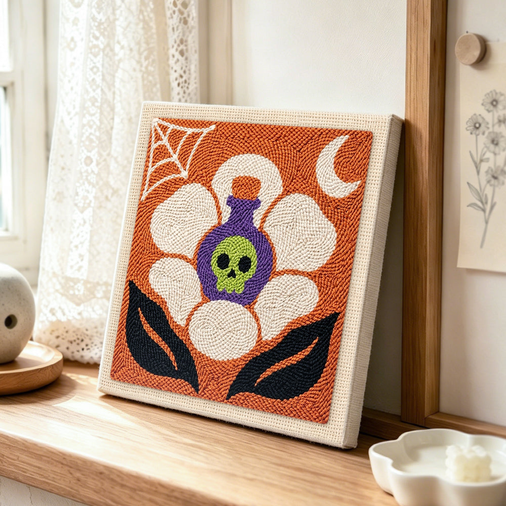Poison skull blossom punch needle artwork displayed on a table