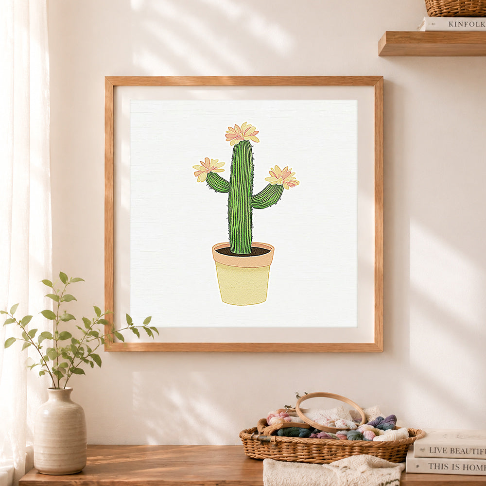 Finished potted cactus with pink blooms cross stitch artwork displayed as home decor