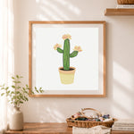 Finished potted cactus with pink blooms cross stitch artwork displayed as home decor
