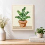 Finished potted green fern artwork displayed on a wall