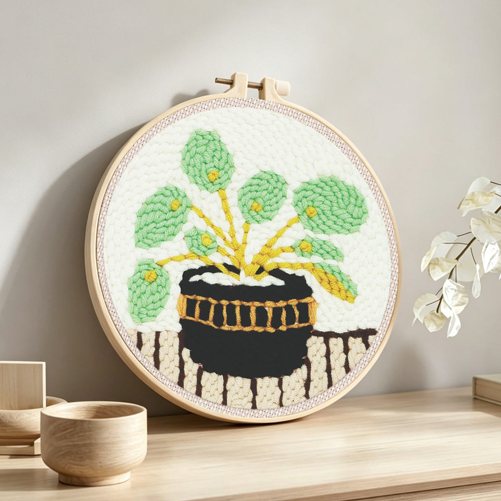 Potted green plant punch needle artwork displayed on a table