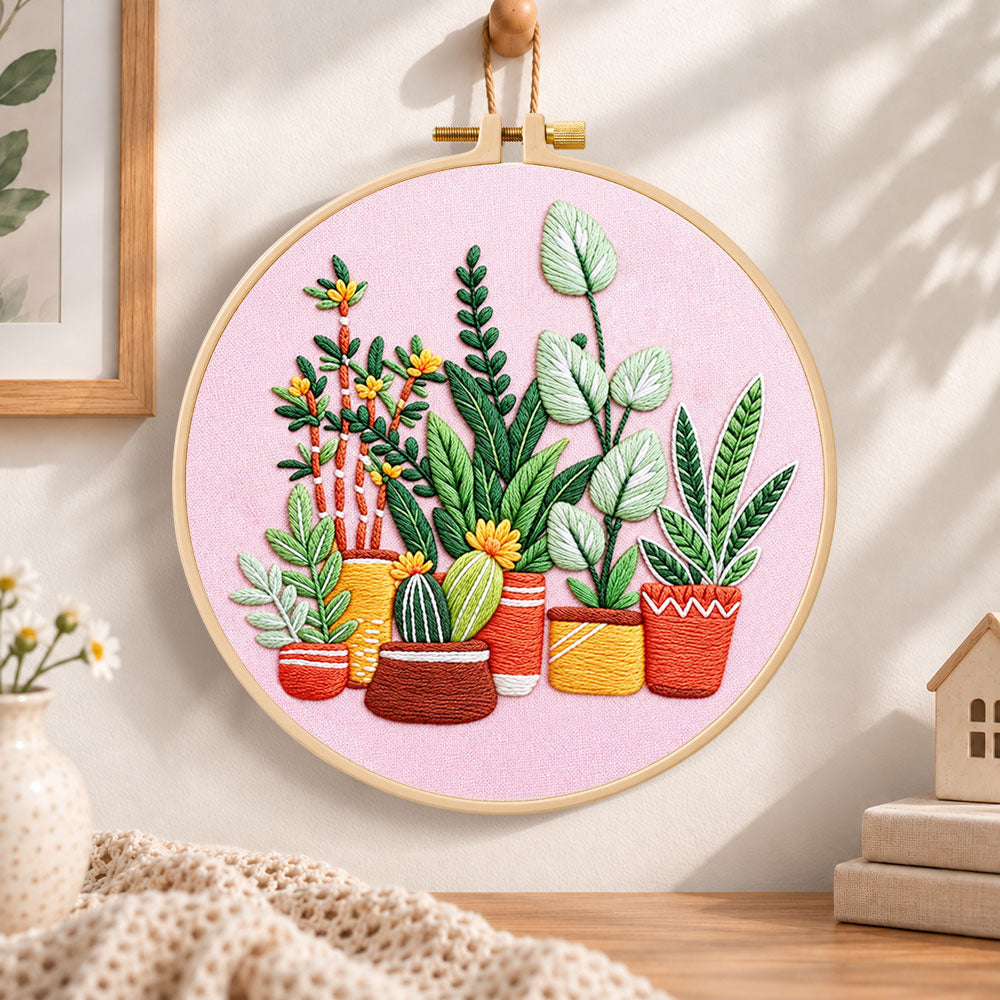 Potted plants on pink fabric embroidery hoop wall art displayed as warm and cozy handmade home decor