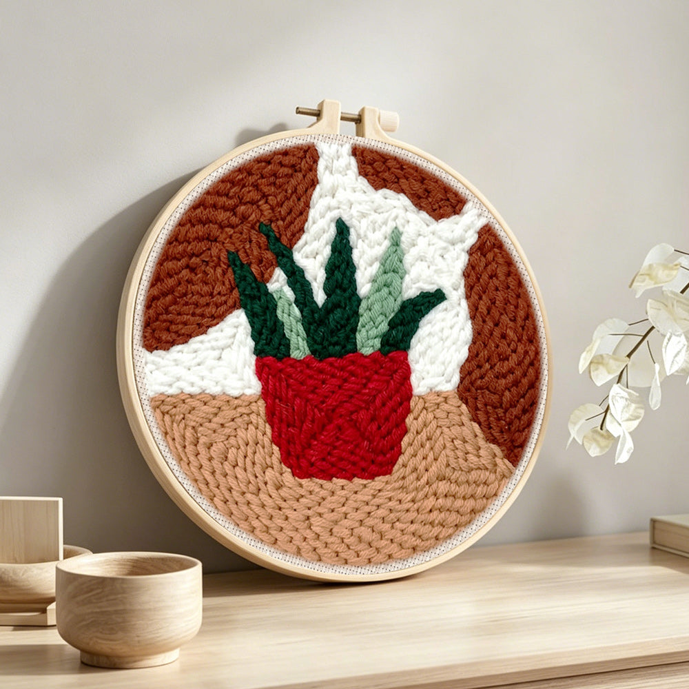 Potted succulent punch needle artwork displayed on a table