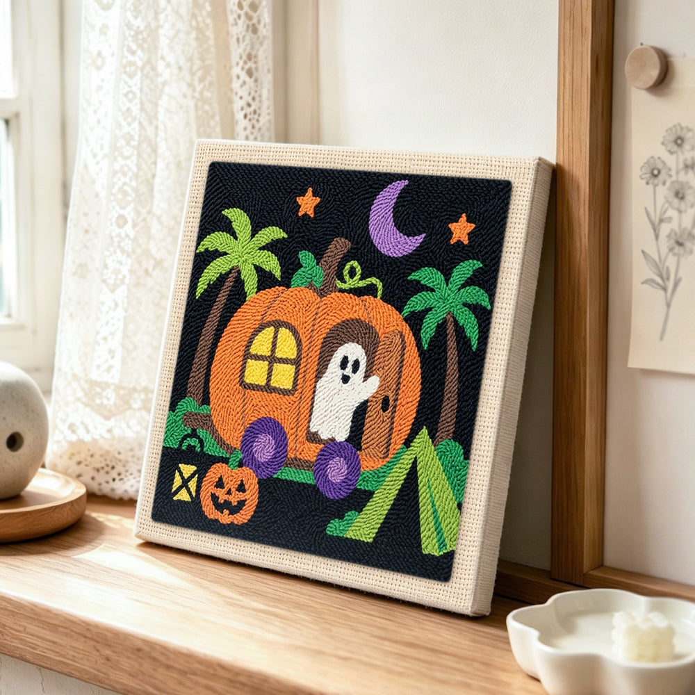 Pumpkin camper ghost punch needle artwork displayed on a table