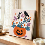 Pumpkin floral crow punch needle artwork displayed on a table