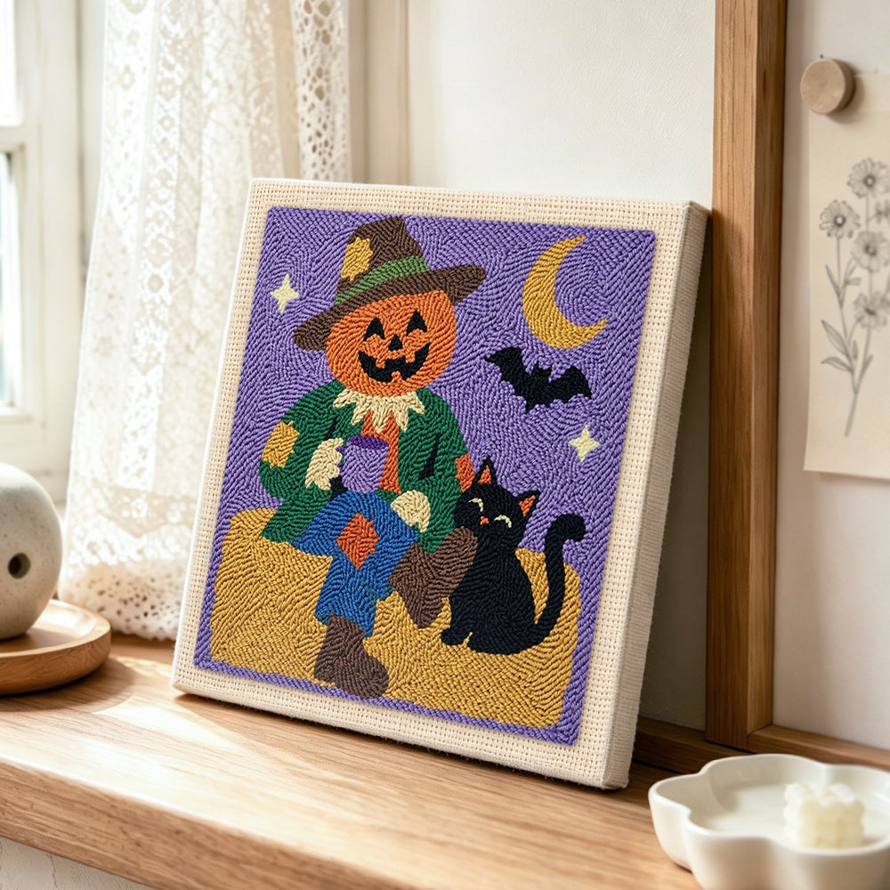 Pumpkin scarecrow punch needle artwork displayed on a table