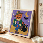 Pumpkin scarecrow punch needle artwork displayed on a table