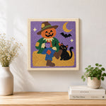 Finished pumpkin scarecrow artwork displayed on a wall