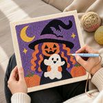 Creating handmade pumpkin witch holding little ghost punch needle artwork