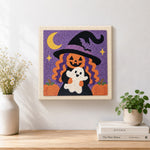 Finished pumpkin witch holding little ghost artwork displayed on a wall