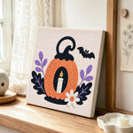Pumpkin with candle punch needle artwork displayed on a table