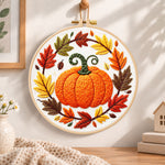 Pumpkin wreath with fall foliage embroidery hoop wall art displayed as warm and cozy handmade home decor