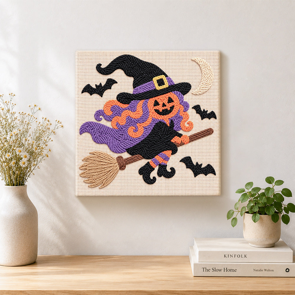 Finished pumpkin witch on broom artwork displayed on a wall