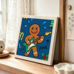 Punk gingerbread man playing guitar punch needle artwork displayed on a table