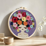 Purple floral crown girl punch needle artwork displayed on a table