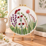 Purple meadow flowers embroidery kit finished hoop displayed on a wooden stand as cozy tabletop decor