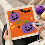 Creating handmade purple pumpkin and bat punch needle artwork