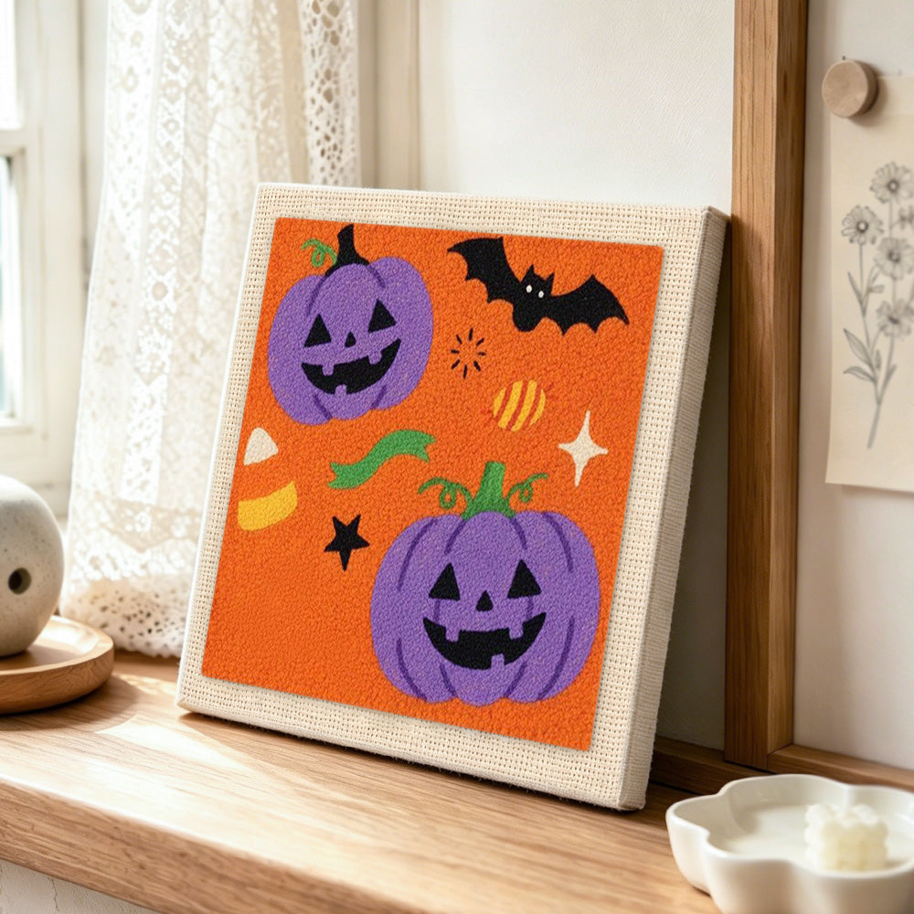 Purple pumpkin and bat punch needle artwork displayed on a table