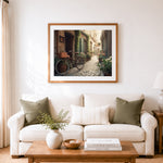 Finished quiet european alley cross stitch artwork displayed as home decor