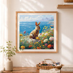 Finished rabbit sitting on coastal rocky shore cross stitch artwork displayed as home decor