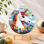 Finished rainbow unicorn with flowers needle felting displayed on a wooden easel