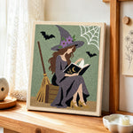 Reading witch with spell book punch needle artwork displayed on a table
