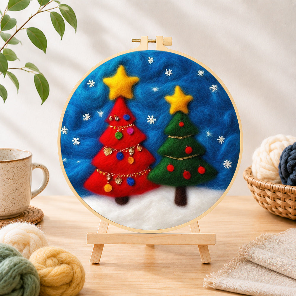 Finished red and green christmas trees with snowflakes needle felting displayed on a wooden easel