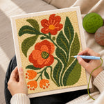 Creating handmade red and orange floral with leaves punch needle artwork
