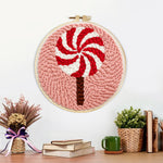 Finished red and white swirl lollipop artwork displayed on a wall
