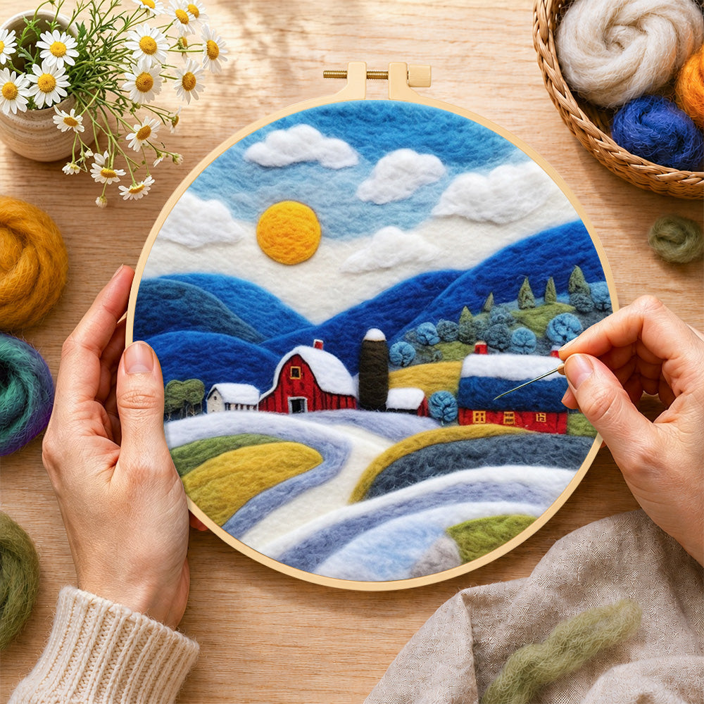Creating the red barn and snowy blue hills wool painting by hand with a felting needle