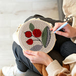 Creating handmade red berries with green leaves punch needle artwork