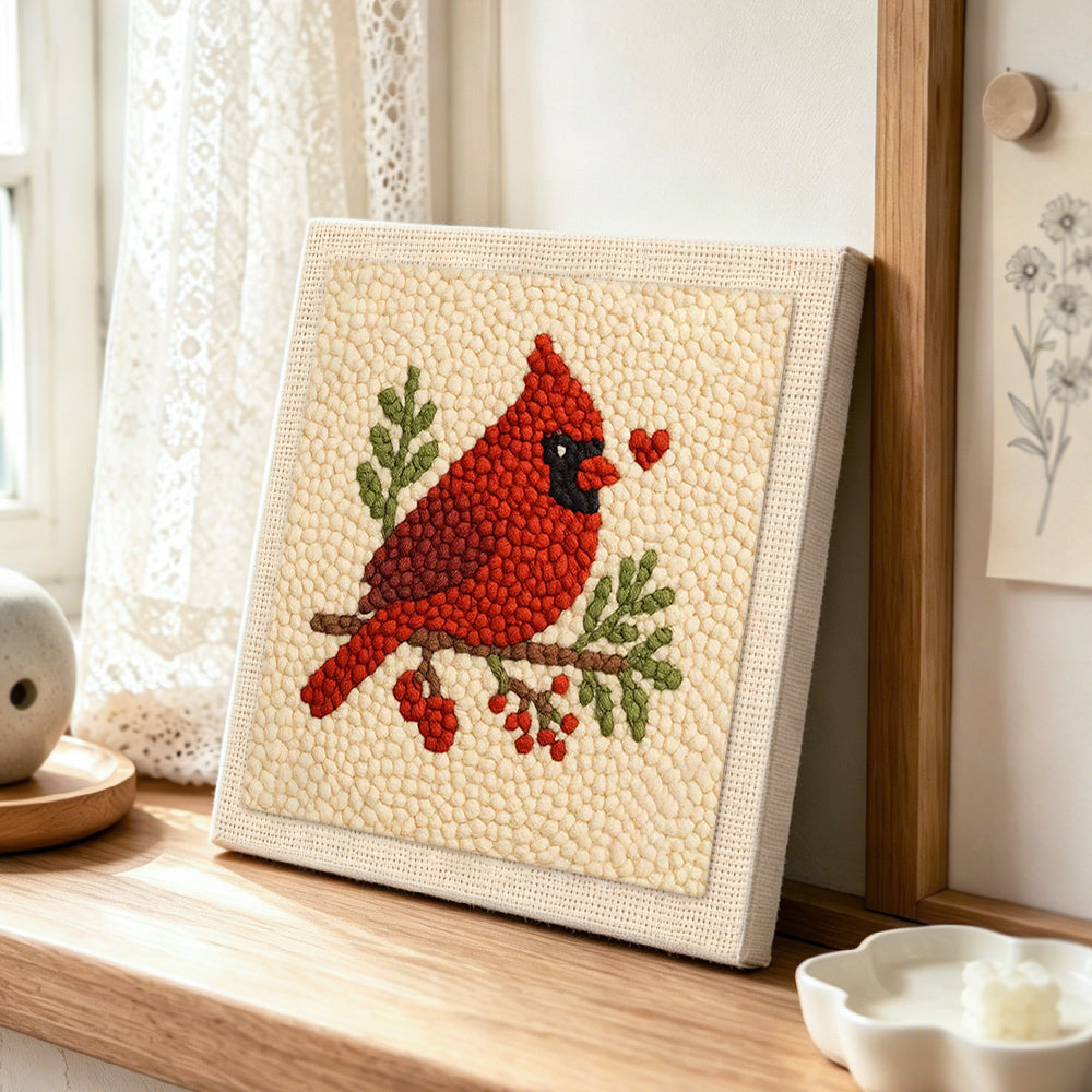 Red cardinal with heart punch needle artwork displayed on a table