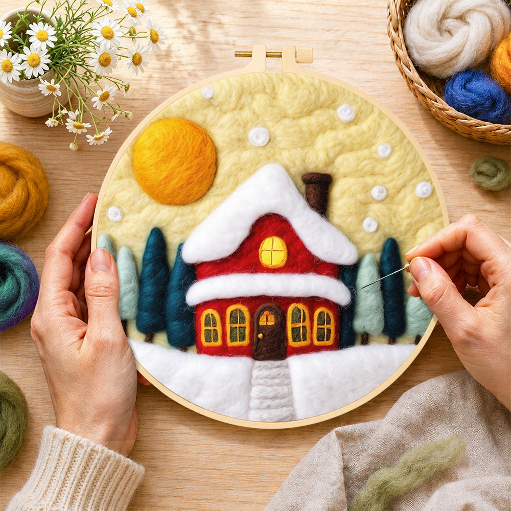 Creating the red cottage under snowy yellow sky wool painting by hand with a felting needle