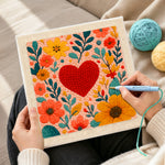 Creating handmade red heart surrounded by colorful blooms punch needle artwork