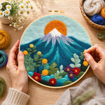 Creating the red sun over snowy peaks wool painting by hand with a felting needle