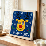 Reindeer naughty list art punch needle artwork displayed on a table