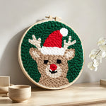 Reindeer with santa hat punch needle artwork displayed on a table