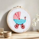 Retro baby pram punch needle artwork displayed on a table