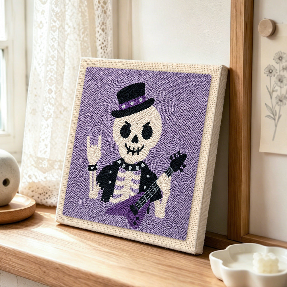 Rocker skeleton punch needle artwork displayed on a table