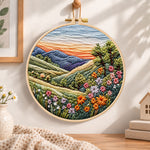 Rolling hills floral vista embroidery hoop wall art displayed as warm and cozy handmade home decor