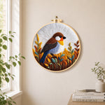 Rustic autumnal bird on golden grasses needle felt wall art displayed in a bright home interior