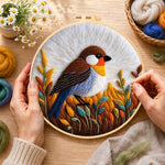Creating the rustic autumnal bird on golden grasses wool painting by hand with a felting needle
