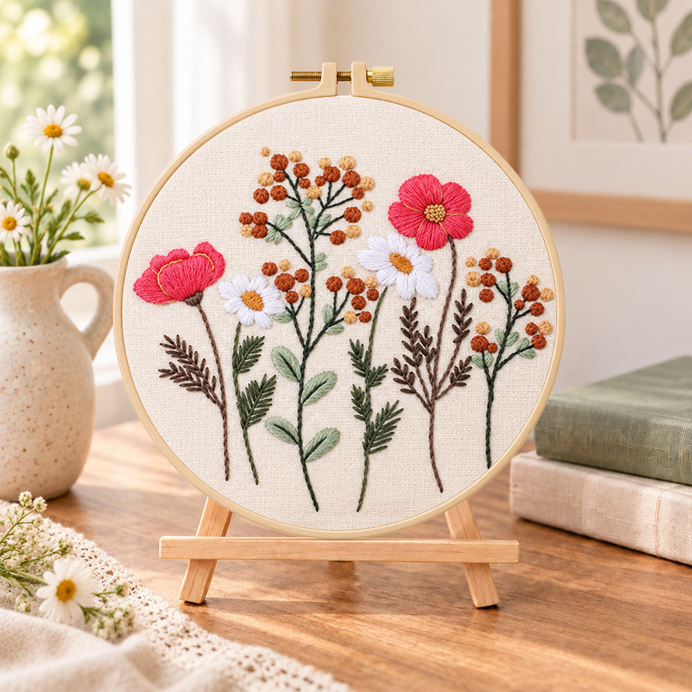 Rustic wild stems embroidery kit finished hoop displayed on a wooden stand as cozy tabletop decor