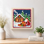 Finished santa and cabin christmas artwork displayed on a wall