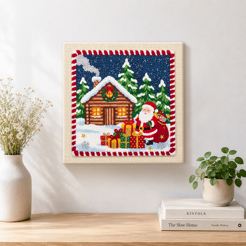 Finished santa and cabin christmas artwork displayed on a wall