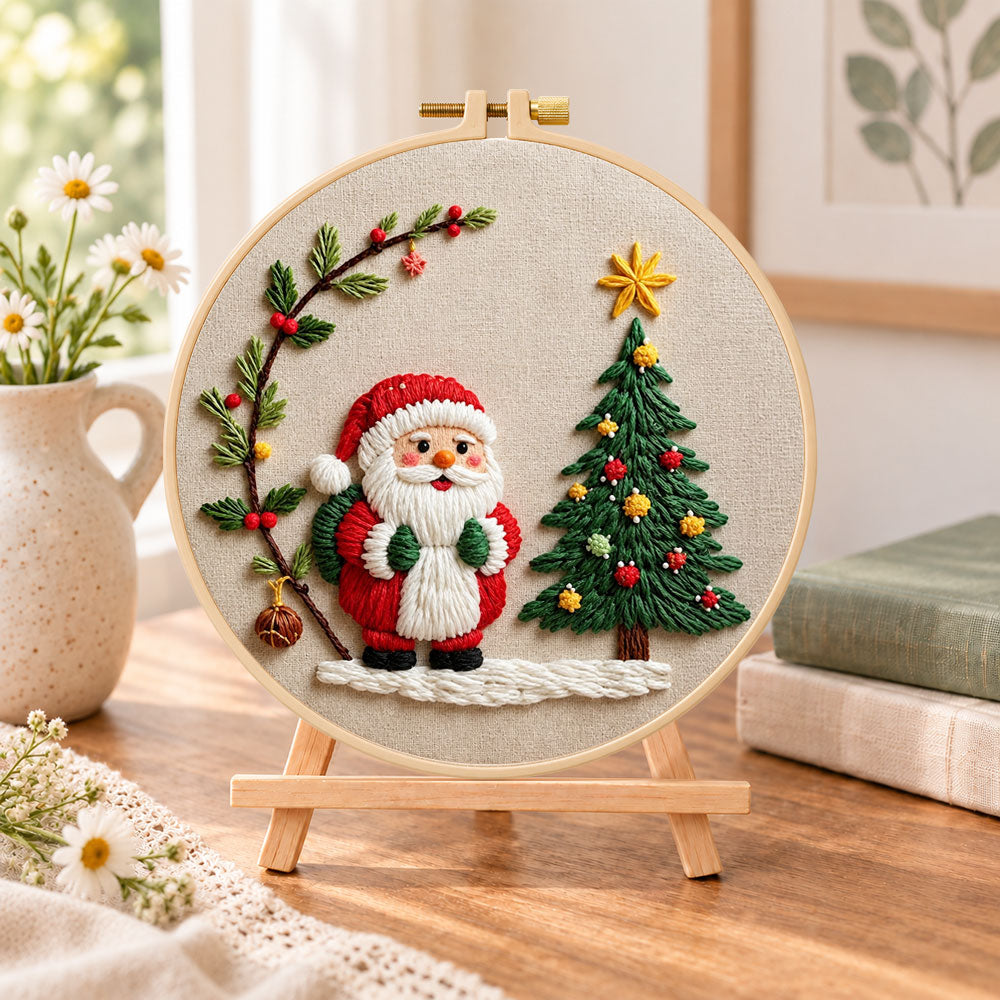 Santa and christmas tree embroidery kit finished hoop displayed on a wooden stand as cozy tabletop decor