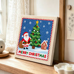 Santa beside christmas tree punch needle artwork displayed on a table