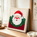 Santa claus portrait punch needle artwork displayed on a table