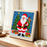 Santa holding gift sack punch needle artwork displayed on a table