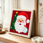 Santa with christmas tree punch needle artwork displayed on a table